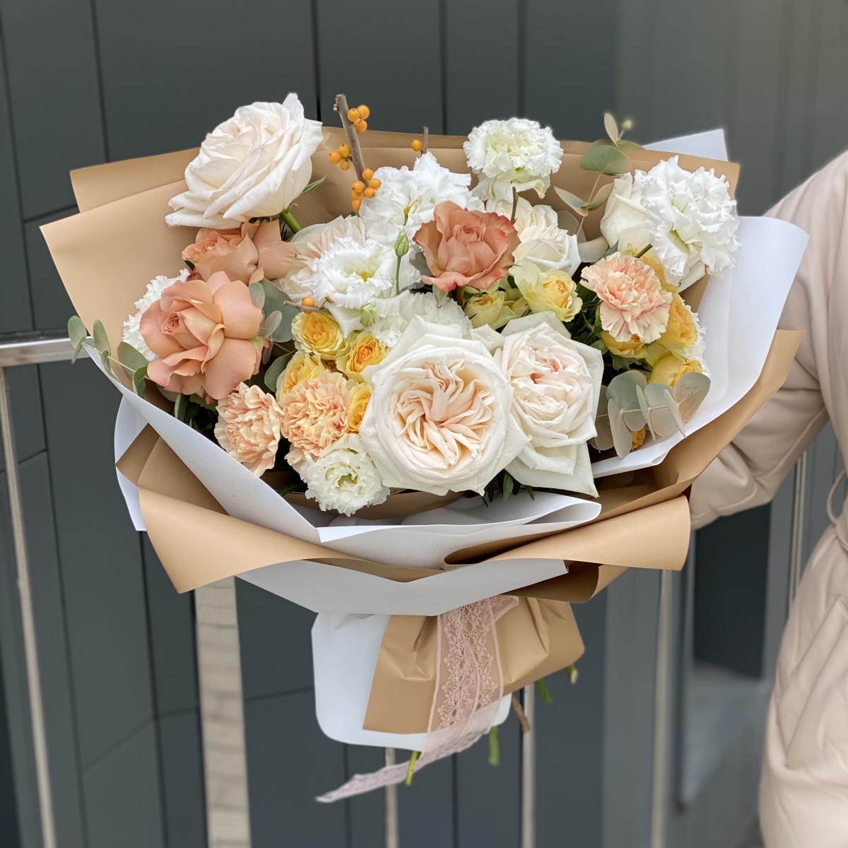 Букет Аделаида из илекса, эустомы , кустовых роз, роз сорта капучино и охара